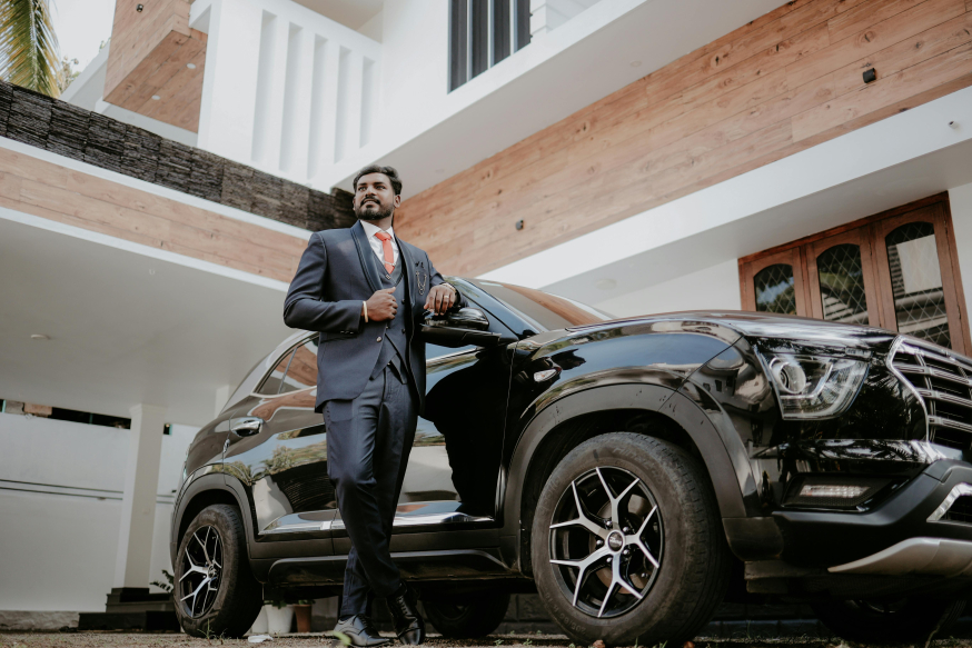 Waarom elektrisch rijden in 2026 een zakelijke prestatiekeuze is Afbeelding: Zakelijke rijder staat naast een representatieve elektrische SUV bij een modern gebouw